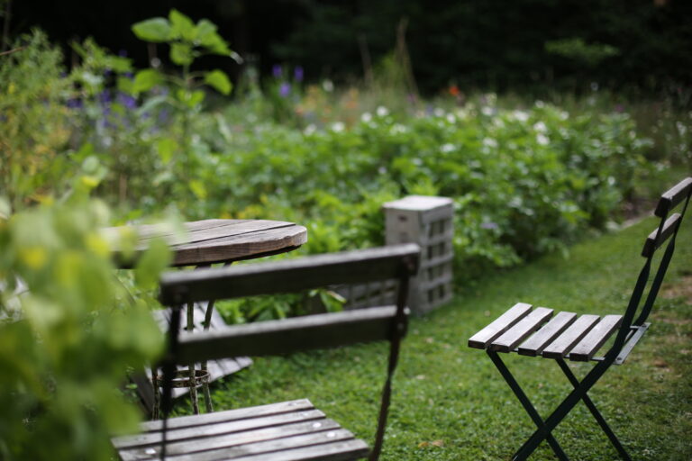 Jardin avec table en bois et chaises.